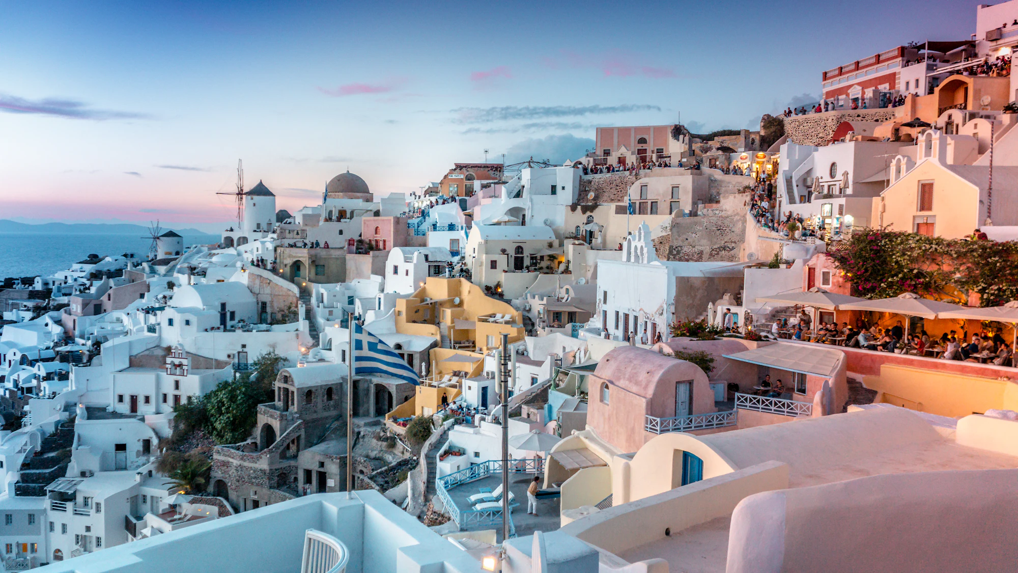 A whitewashed Cycladic village above the Aegean at dusk