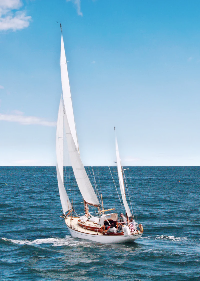 A sailboat under full sail on open blue water